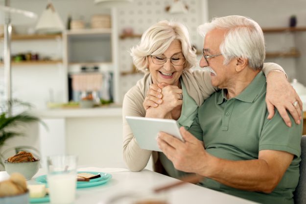 Happy senior couple using digital tablet at home. Happier Retirement: Fun Senior Living Activities In Florida