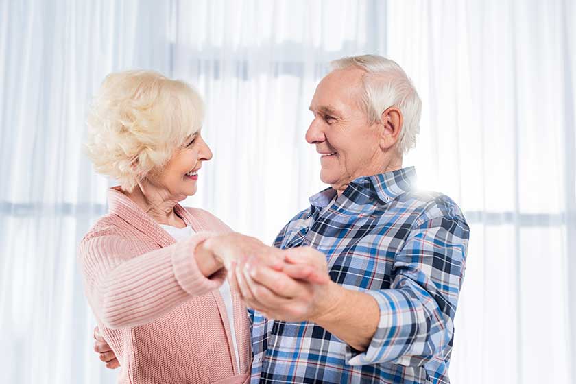 Side view of smiling senior couple dancing together Side view of smiling senior couple dancing together