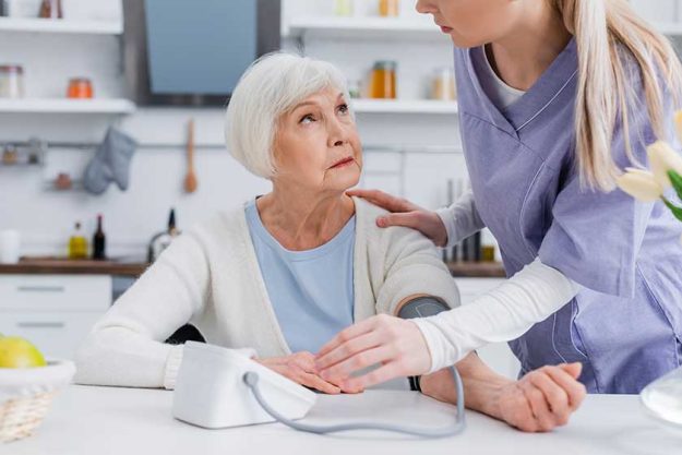 Social worker touching shoulder of elderly woman Social worker touching shoulder of elderly woman