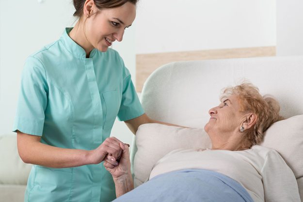 Supportive nurse with old lady