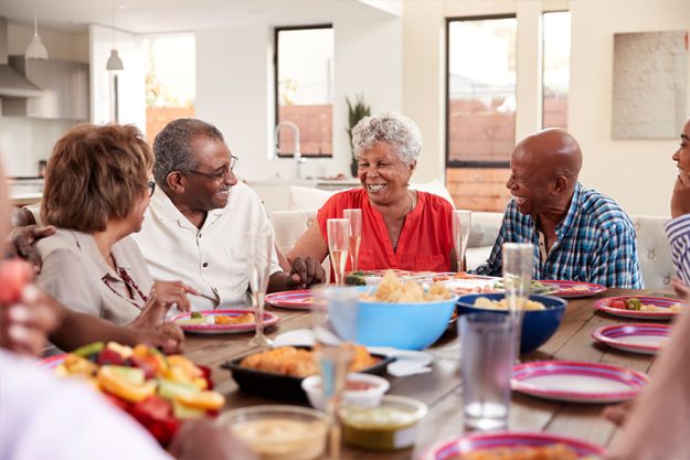 Grandfather making a toast at the dinner table celebrating with his family