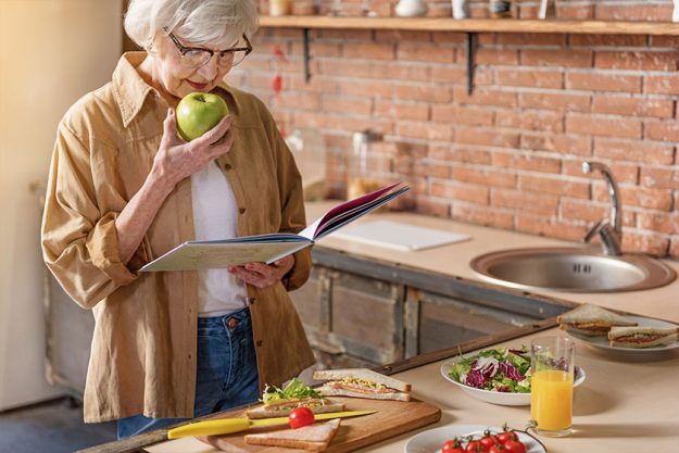 Happy mature lady cooking at home Happy mature lady cooking at home