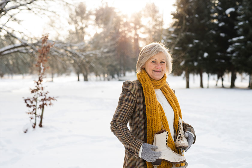 Senior woman in winter nature going ice skating