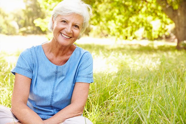 Senior woman sitting on grass Senior woman sitting on grass