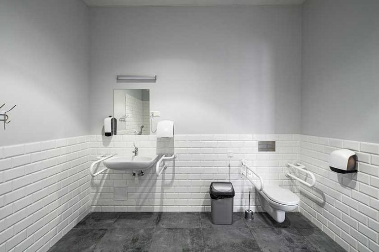 The interior of bathroom with facilities for the disabled. White bricks. Grey tile