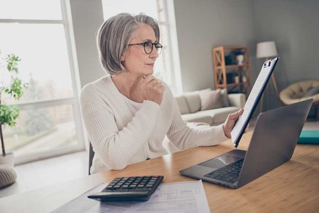 Photo of smart thoughtful elderly lady executive wear white reading documents before signing modern device indoors apartment room Photo of smart thoughtful elderly lady executive wear white reading documents before signing modern device indoors apartment room