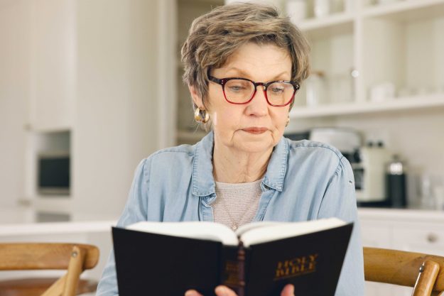 Reading, Bible and old woman in home with Christian worship, prayer or education in faith. Elderly, person and studying holy gospel, religion or trust in God with spiritual learning in retirement. Reading, Bible and old woman in home with Christian worship, prayer or education in faith. Elderly, person and studying holy gospel, religion or trust in God with spiritual learning in retirement.