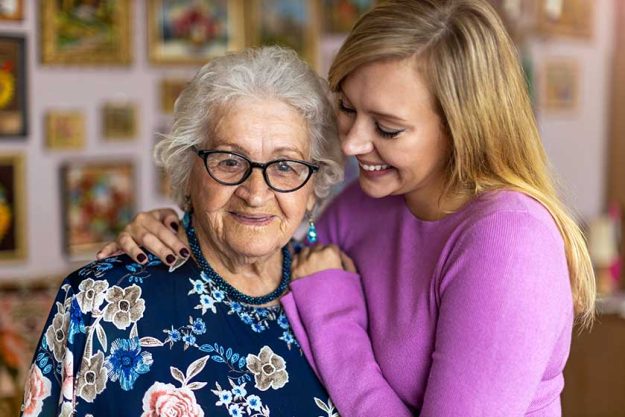 Young woman spending time with her elderly grandmother at home