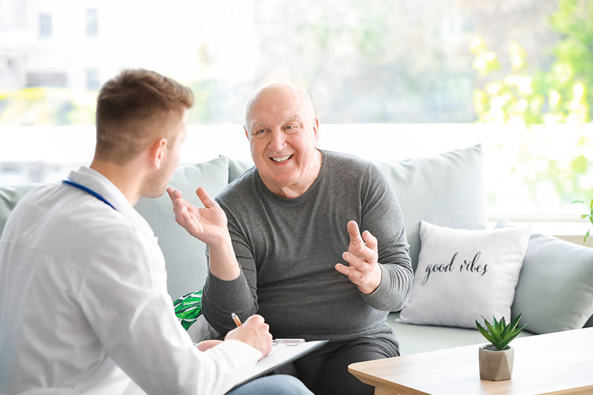 doctor examining senior man in nursing home