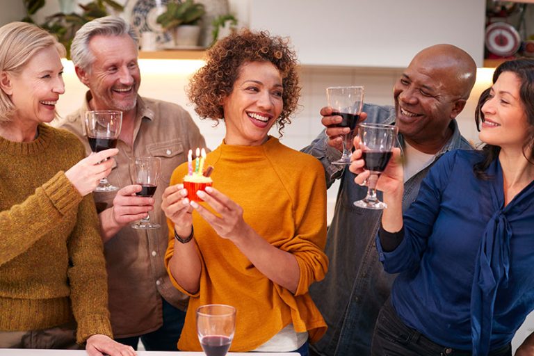 group mature friends meeting home celebrate womans birthday cake