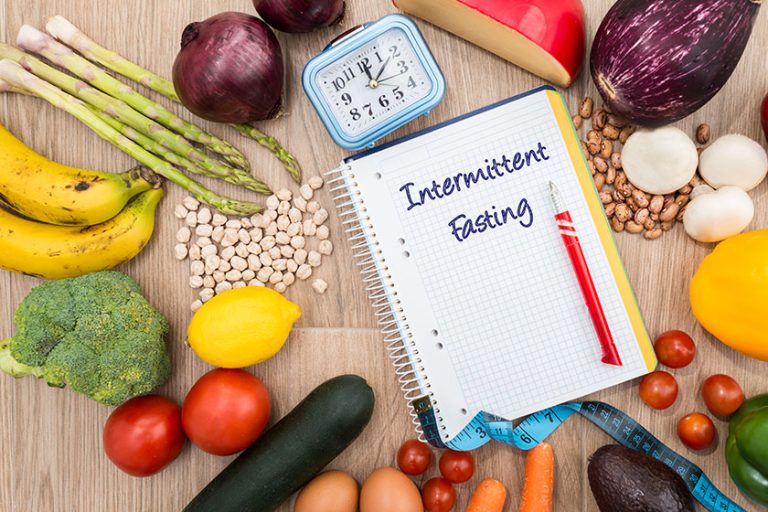 Healthy food around a notebook and a clock
