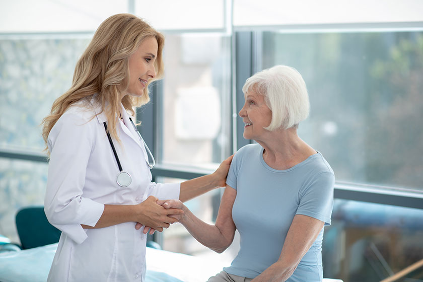Long-haired cute smiling nurse talking to an elder Women Long-haired cute smiling nurse talking to an elder Women