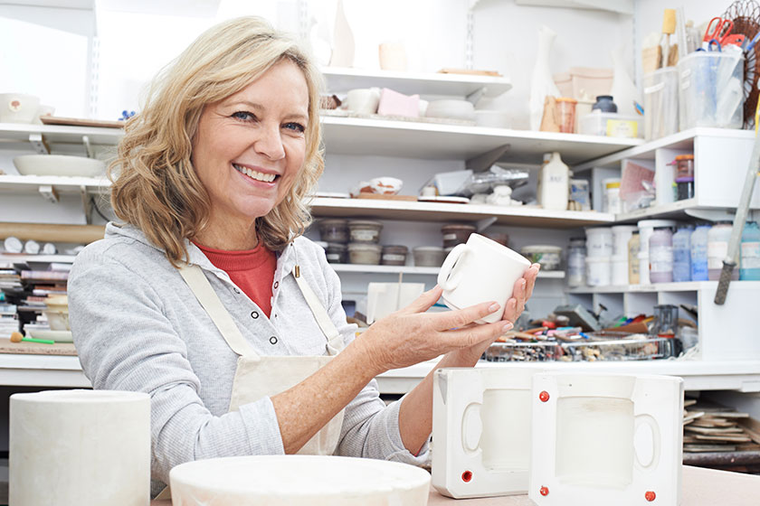 Portrait Of Mature Woman In Pottery Studio Casting Mug