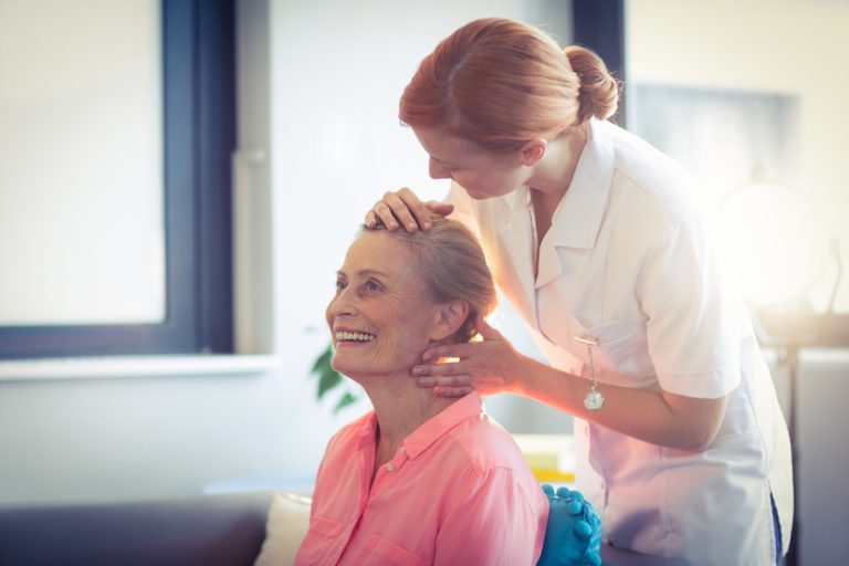 Female nurse giving head massage to woman Female nurse giving head massage to woman