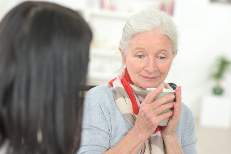Sad senior woman drinking a coffee