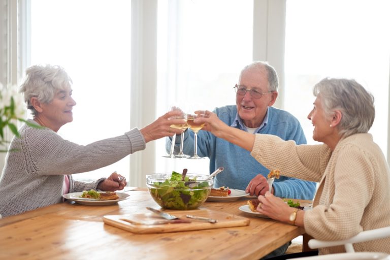 To good friends and good food. A senior man and two senior women enjoying lunch. To good friends and good food. A senior man and two senior women enjoying lunch.