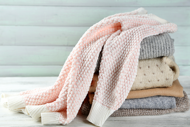 Knitting clothes on wooden background