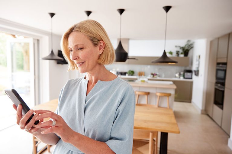 Mature Woman Using App On Mobile Phone To Control Mature Woman Using App On Mobile Phone To Control