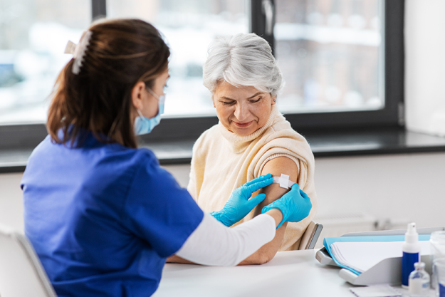 Nurse applying medical patch to vaccinated woman