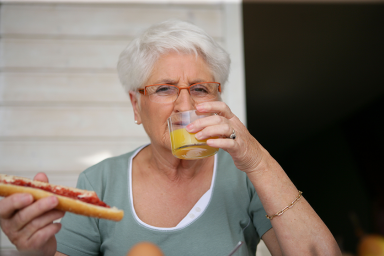 Portrait of a senior woman drinking a glass of orange juice Portrait of a senior woman drinking a glass of orange juice