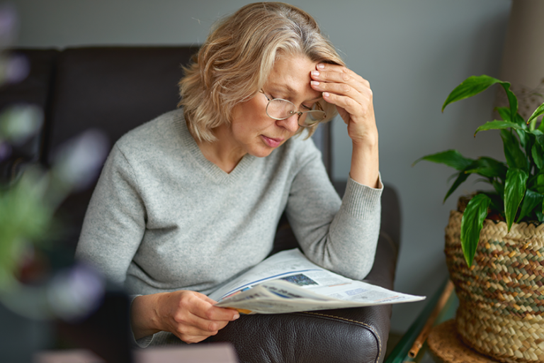 Shocked,woman reading newspaper, bad news Shocked,woman reading newspaper, bad news