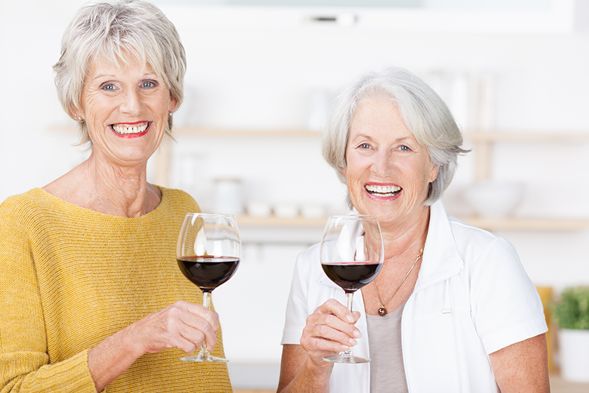 Two senior friends enjoying a glass of red wine Two senior friends enjoying a glass of red wine