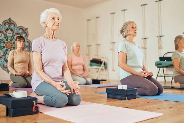 Yoga, lotus and group of senior women in gym meditating for spiritual health Yoga, lotus and group of senior women in gym meditating for spiritual health