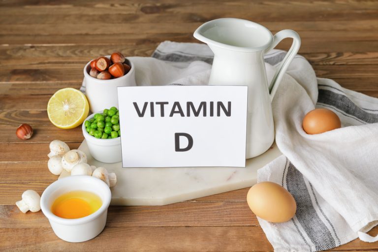 Text VITAMIN D and different healthy products on wooden backgrou Text VITAMIN D and different healthy products on wooden backgrou