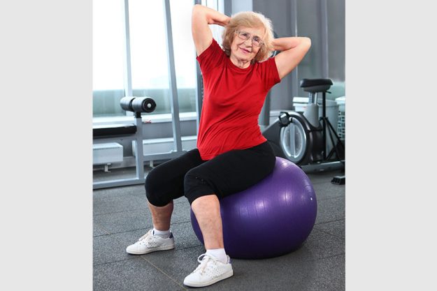 An elderly woman is engaged with a fitness ball An elderly woman is engaged with a fitness ball