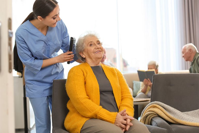 Care worker brushing elderly woman geriatric hospice Care worker brushing elderly woman geriatric hospice