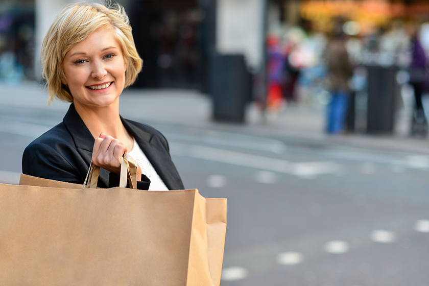Cheerful business woman holding shopping bag Cheerful business woman holding shopping bag