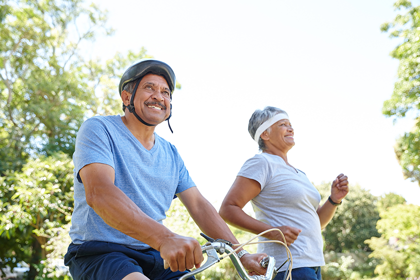happy senior couple going for a bike ride