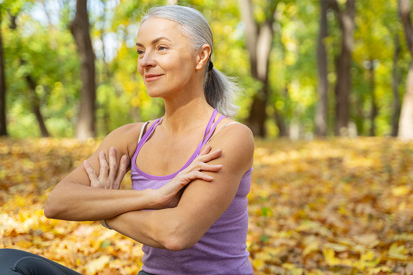 Focused woman with crossed arms sitting outside Focused woman with crossed arms sitting outside
