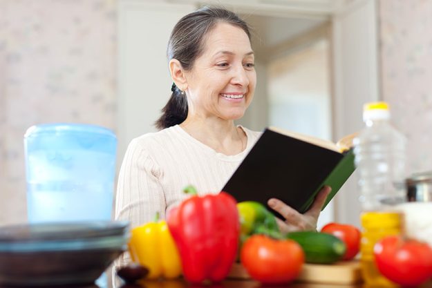 Mature woman reads cookbook