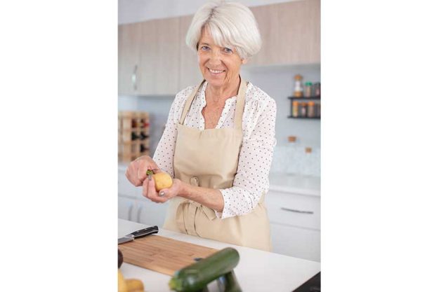 attractive mature woman peeling potatoes kitchen attractive mature woman peeling potatoes kitchen