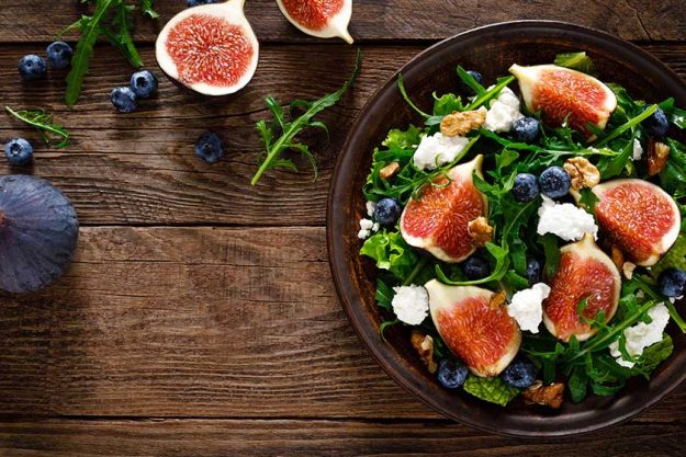 fig salad goat cheese blueberry walnuts arugula wooden background healthy