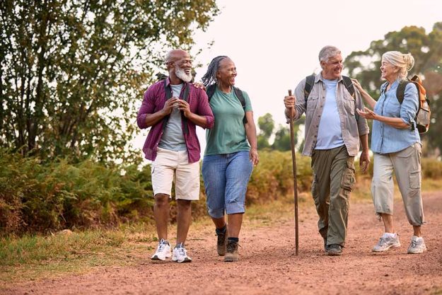 group active senior friends enjoying hiking countryside walking track togethe