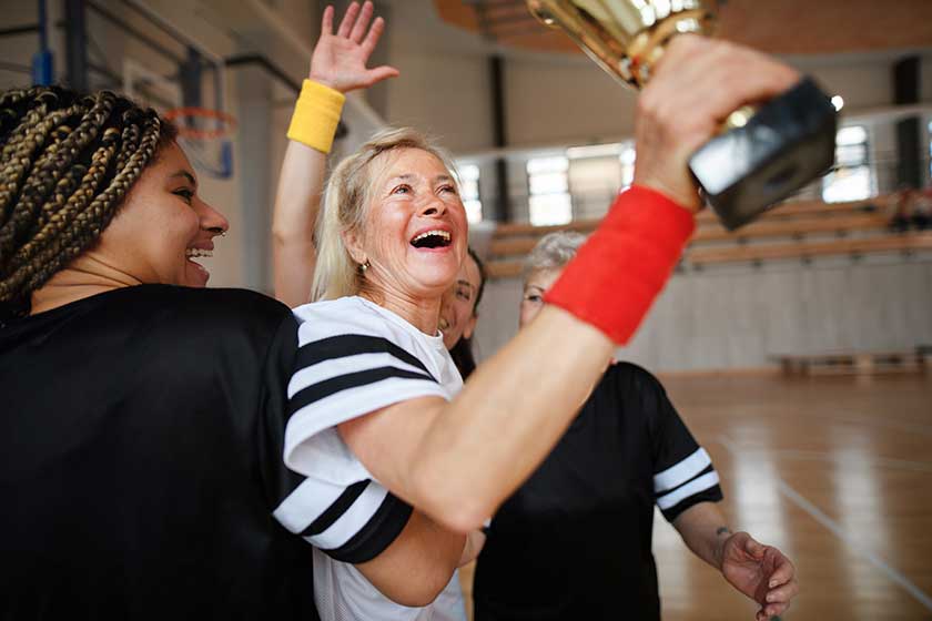 group young old cheerful women floorball team players gym cebrating