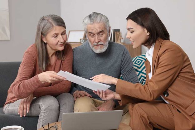 insurance agent consulting elderly couple pension plan room