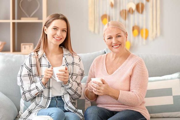 mature woman and her adult daughter spending time together at home