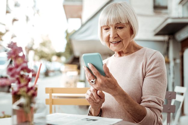 nice elderly woman looking at her smartphone screen