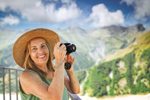portrait smiling happy elderly woman tourist traveling camera posing backdrop
