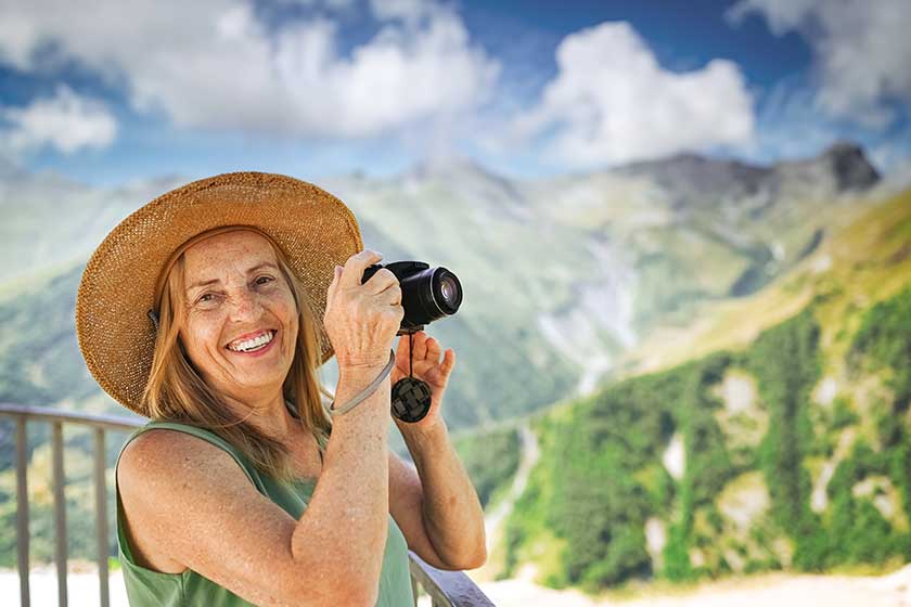 portrait smiling happy elderly woman tourist traveling camera posing backdrop