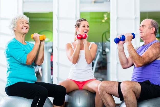 seniors with trainer in gym at sport lifting barbell seniors with trainer in gym at sport lifting barbell