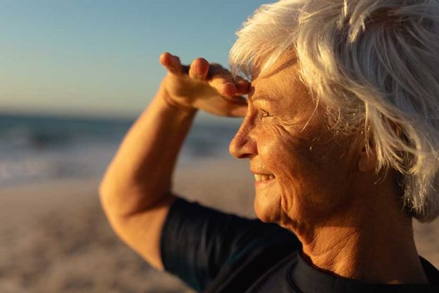 side view close senior caucasian woman beach sunset shielding her side view close senior caucasian woman beach sunset shielding her
