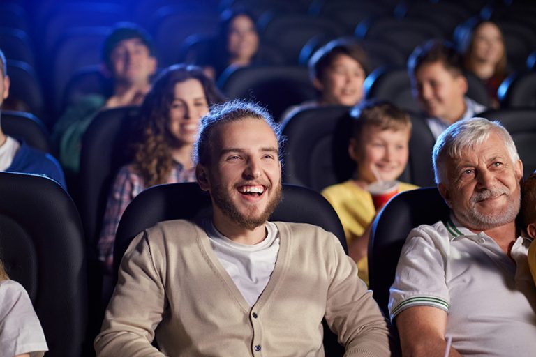 young laughing man in movie theater young laughing man in movie theater