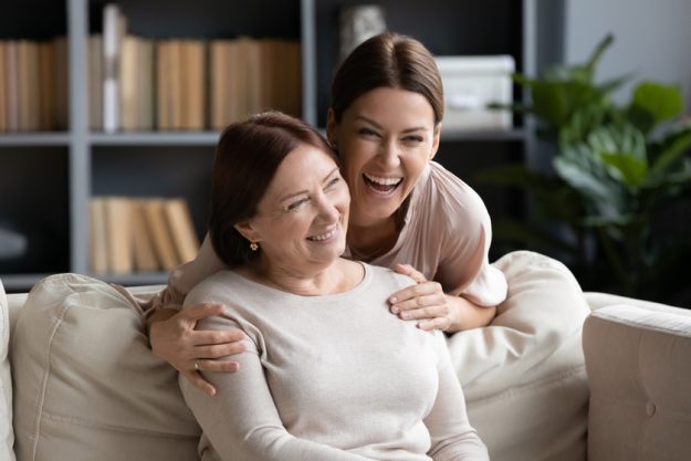 Excited young woman hugging older mother, family having fun Excited young woman hugging older mother, family having fun