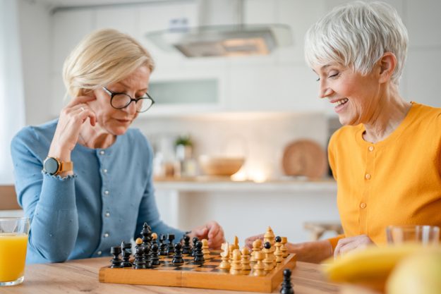 two women mature senior females sisters play chess board game at two women mature senior females sisters play chess board game at