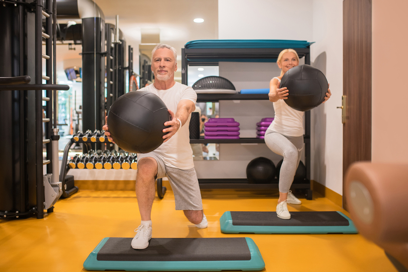 A man and a woman doing lunging with balls A man and a woman doing lunging with balls