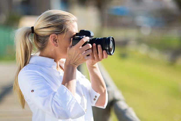 Amateur middle aged photographer shooting pictures outdoors